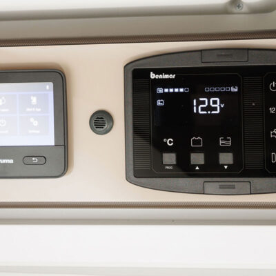 Dual ceiling control panels: a Truma touchscreen on the left and a black digital panel showing 12.9V on the right.